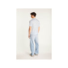 Homme portant une chemise légère et moderne avec un pantalon en jeans, vu de dos.