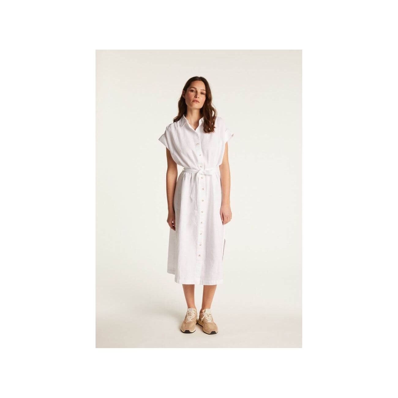 Femme portant la robe Emy en lin blanc, élégante et respirante, parfaite pour un look chic et décontracté.