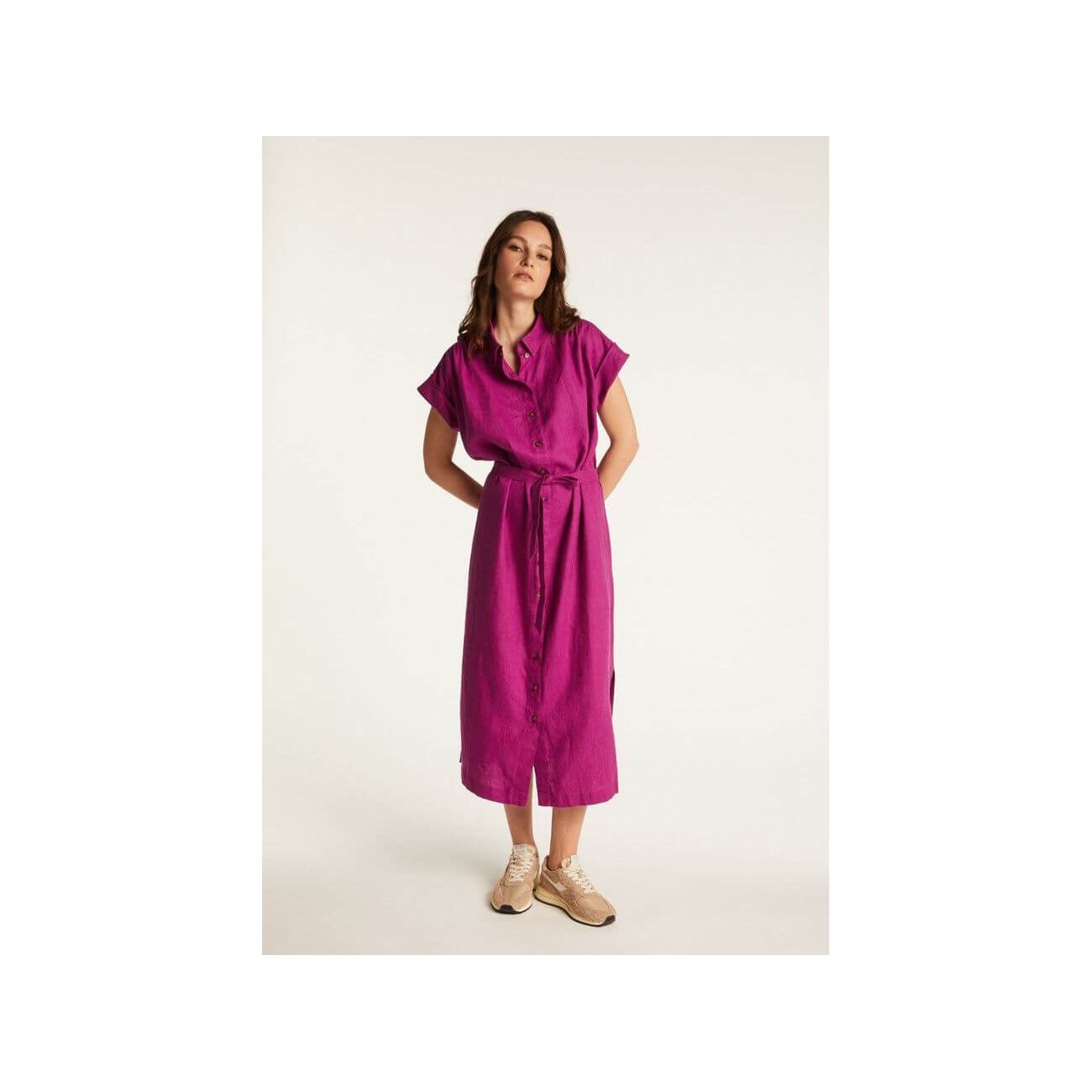 Femme portant la robe Emy, en lin léger, couleur fuchsia, offrant élégance et confort pour la saison.