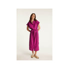 Femme portant la robe Emy, en lin léger, couleur fuchsia, offrant élégance et confort pour la saison.