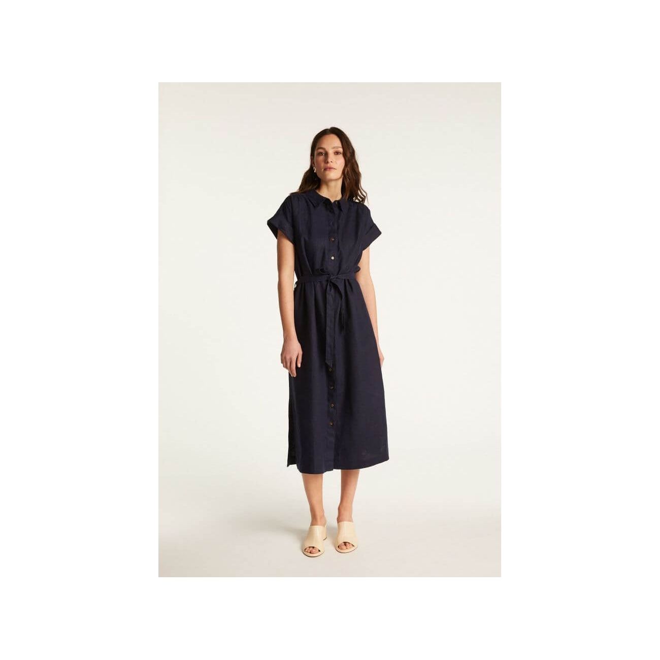 Femme portant la robe Emy, élégante et confortable, en lin léger, avec une coupe fluide et des manches courtes.