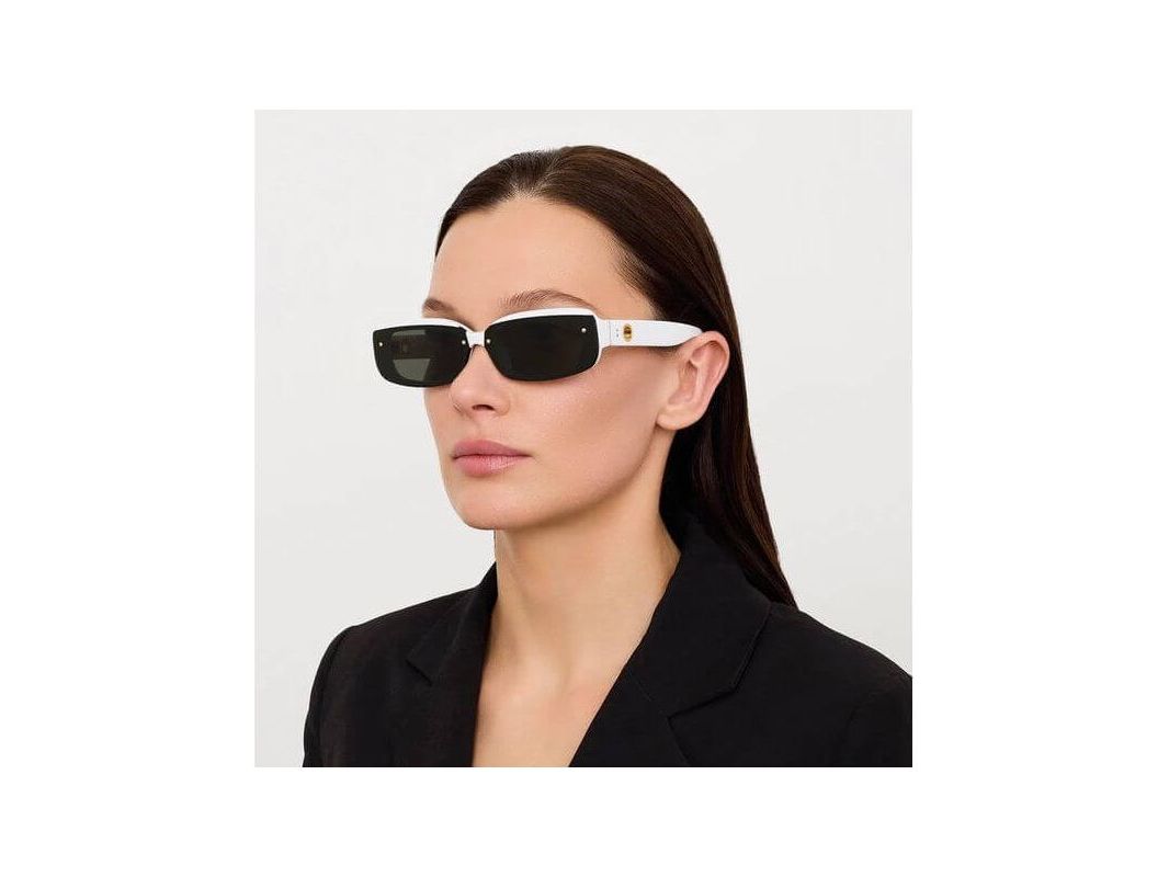 Lunettes de soleil Flick blanches avec verres noirs, offrant élégance et protection UV, portées par une femme.