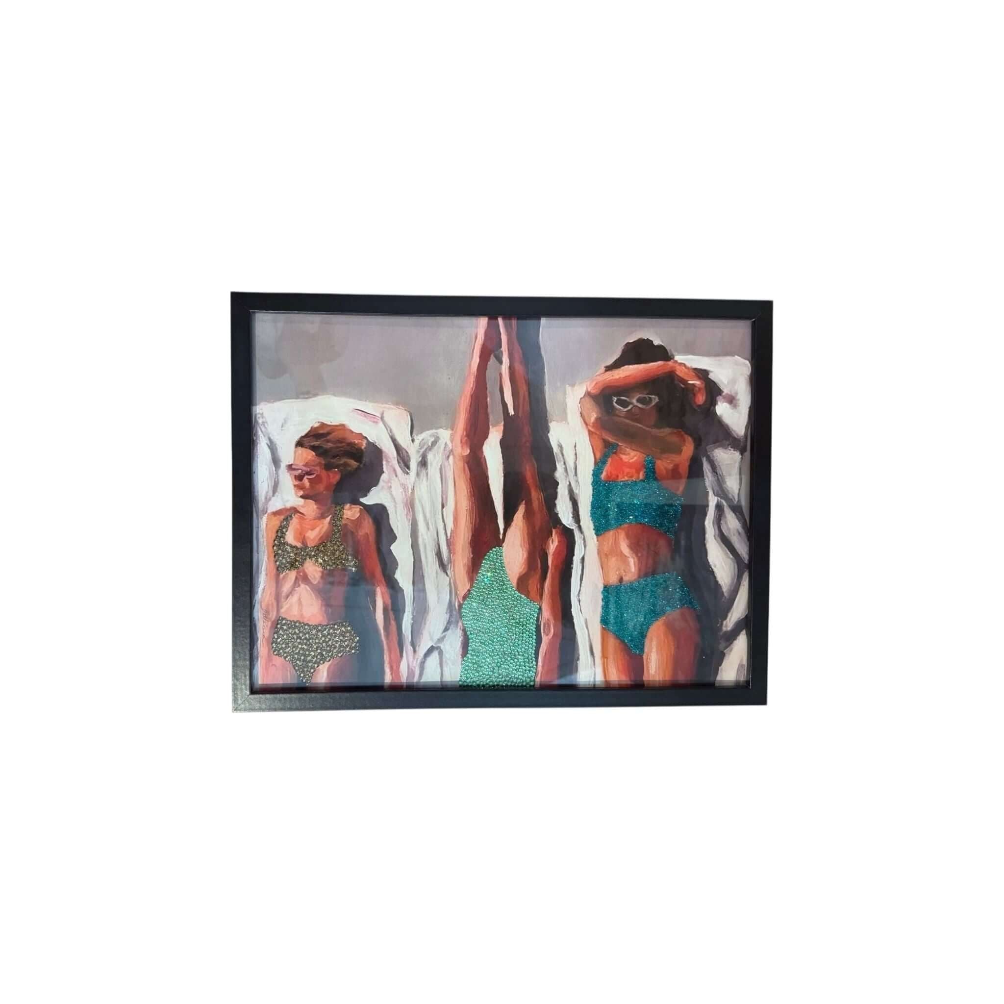 Photo encadrée de trois femmes en maillots de bain bronzant au soleil, ajoutant une touche glamour à votre décoration.