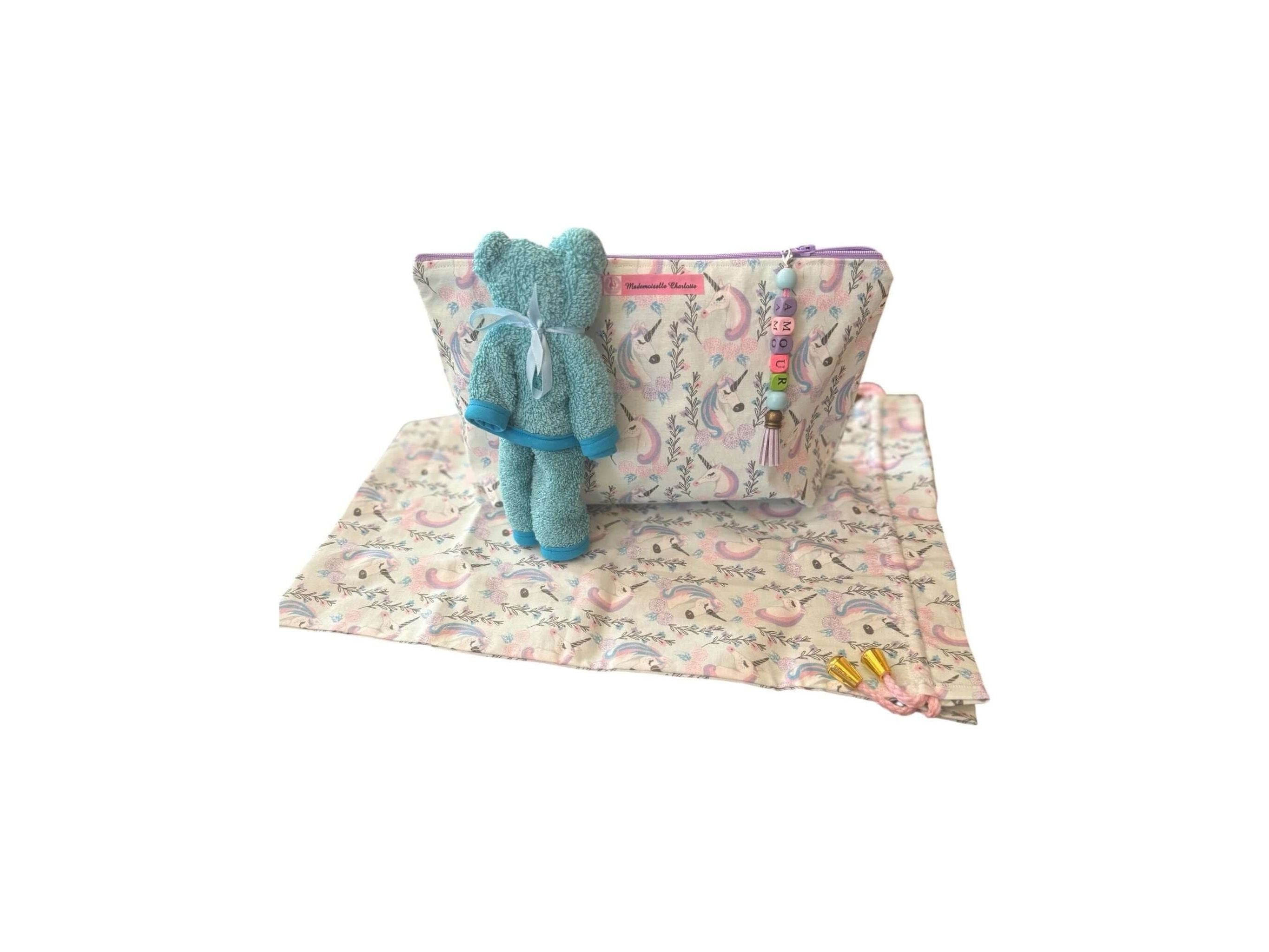 Pochette bébé en tissu avec doudou en peluche et tapis, pratique pour le change lors des déplacements.