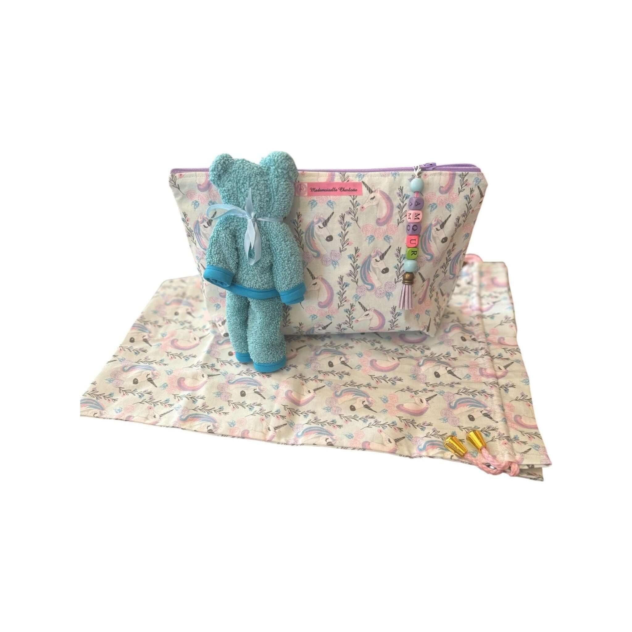 Pochette bébé en tissu avec doudou en peluche et tapis, pratique pour le change lors des déplacements.