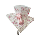 Pochette bébé en tissu floral avec serviettes roulées, parfaite pour le change et les déplacements.