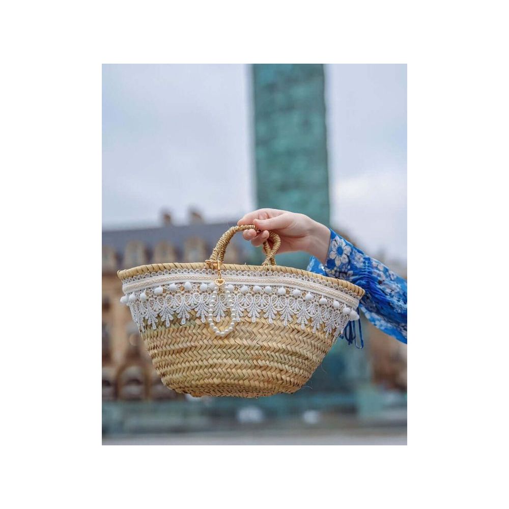 Panier bohème blanc avec dentelle et pompons, léger et élégant pour sorties estivales.