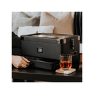 Humidor militaire Black Edition on a table with whiskey glass and modern design, showcasing its unique black matte finish.