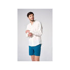 Homme en chemise en lin naturel blanc et short bleu, affichant une coupe classique et élégante.
