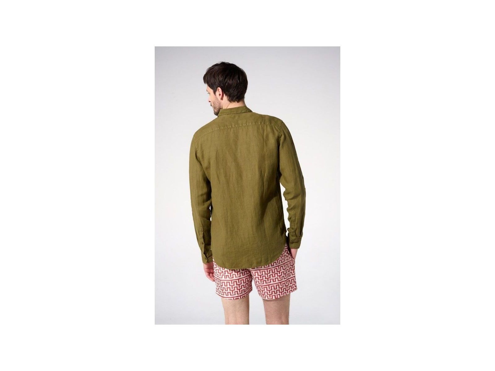 Homme portant une chemise en lin olive vue de dos, associée à un short à motifs.