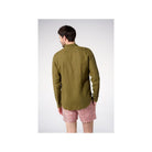 Homme portant une chemise en lin olive vue de dos, associée à un short à motifs.