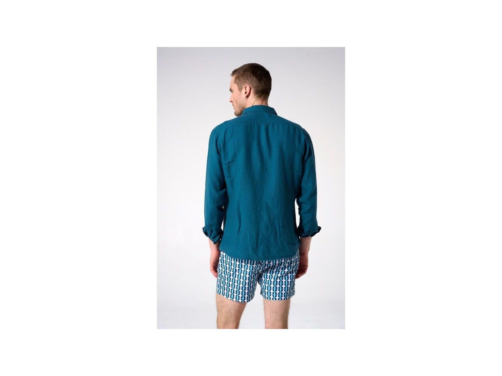 Homme portant une chemise en lin turquoise vue de dos, associée à des shorts imprimés.