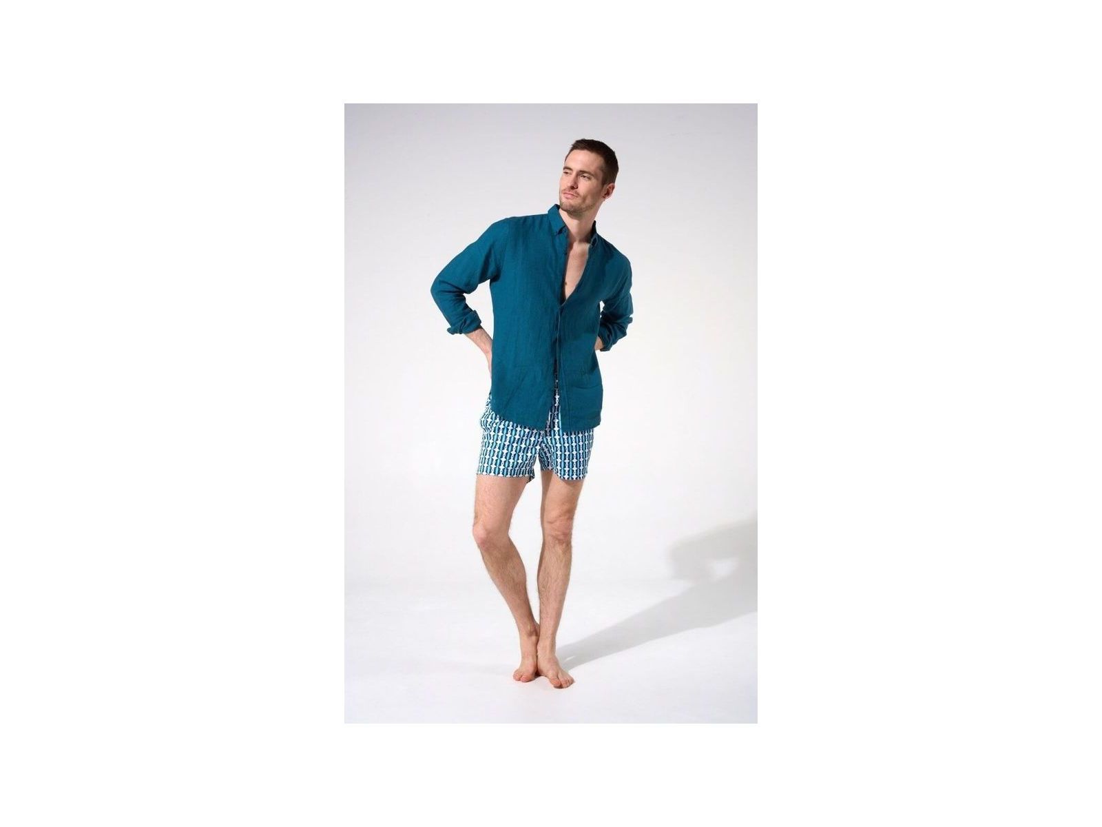 Homme portant une chemise en lin bleu avec un look décontracté, tenue estivale idéale.