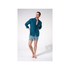 Homme portant une chemise en lin bleu avec un look décontracté, tenue estivale idéale.