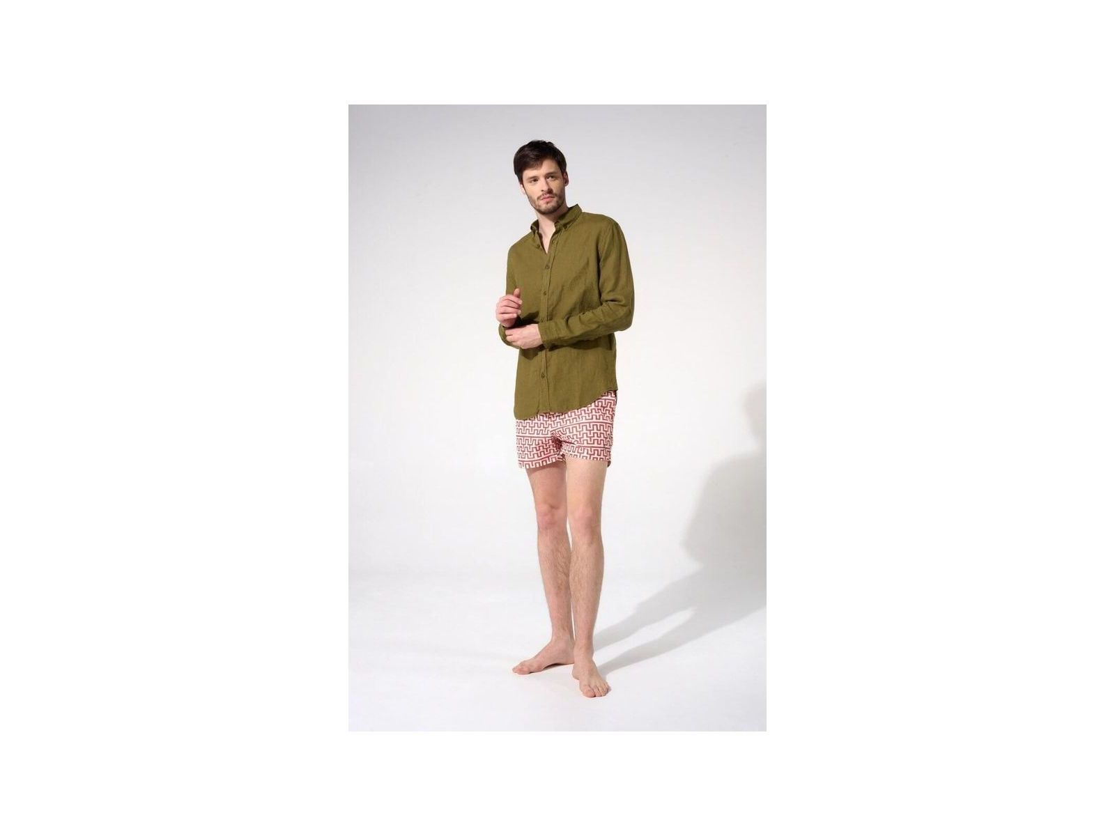 Homme portant une chemise en lin olive avec un pantalon court à motifs, montrant une coupe classique et décontractée.