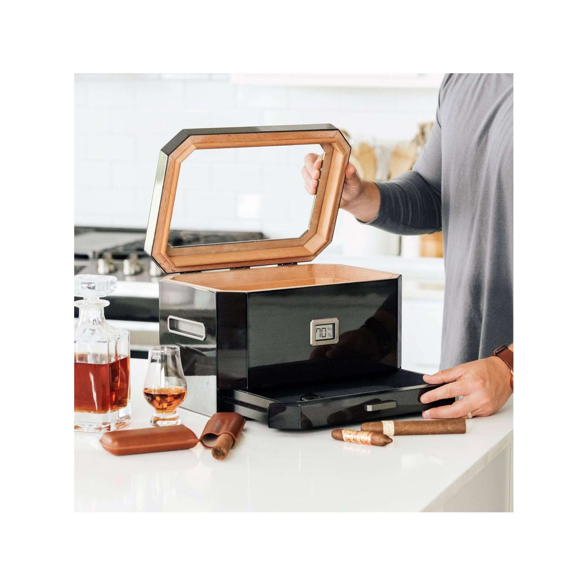 Humidor à couvercle en verre Octodor ouvert, cigare et verre dans une ambiance moderne.