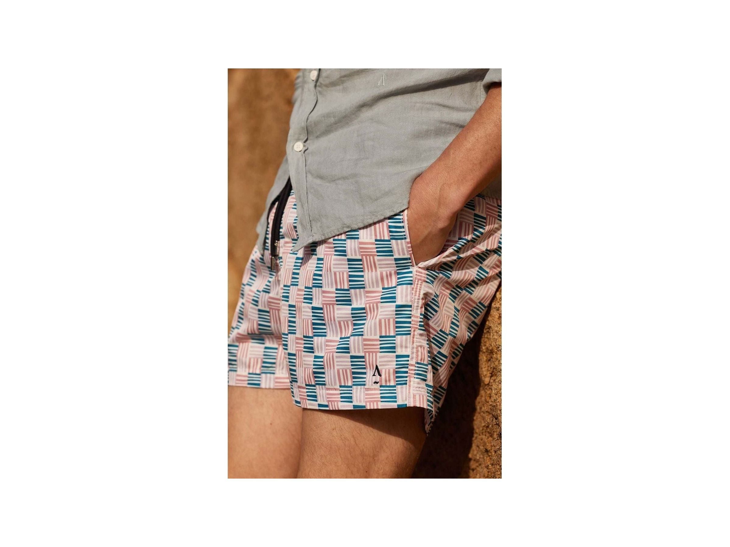 Homme portant des shorts de bain Cannage avec motif géométrique, côté uni, et poche latérale.