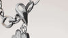 Pendentif croix en argent 925 avec zirconium blanc, élégant et moderne, sur un bracelet.