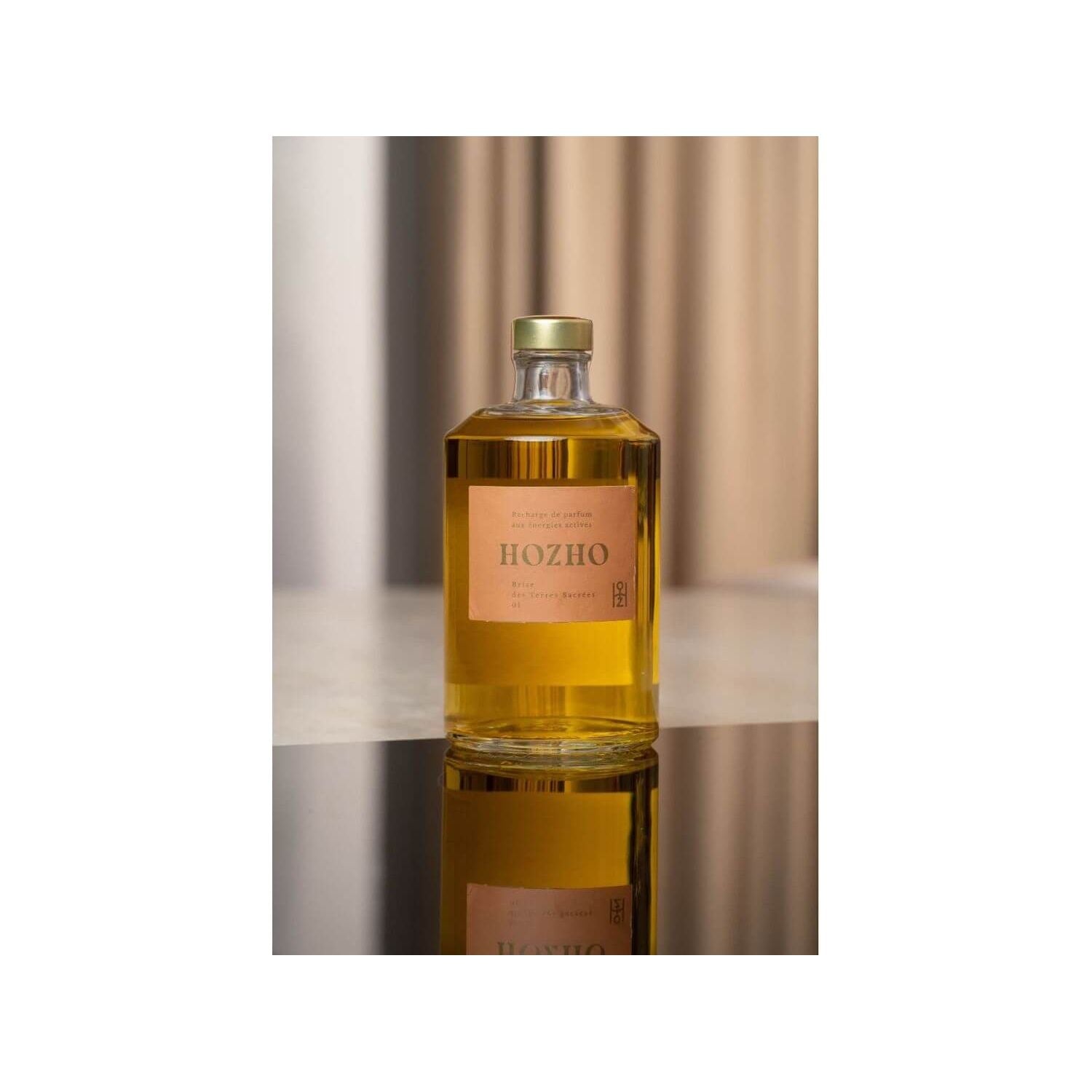 Bouteille de parfum Hozho sur une surface noire, reflétant un design élégant et moderne.